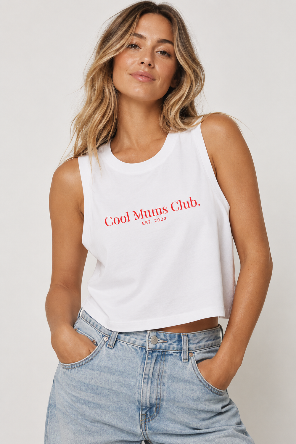 Woman wearing the white CMC Crop Tank with red Cool Mums Club logo